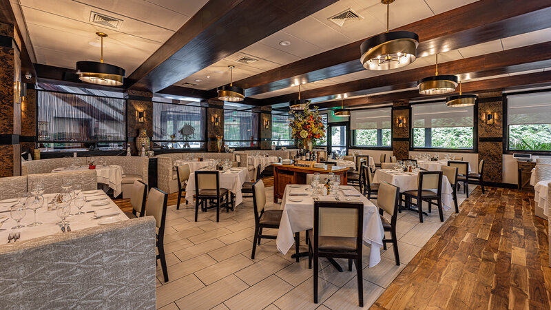 Main dining room with view of set tables and booth seating