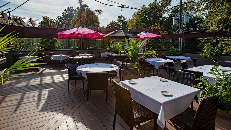 Outdoor patio seating with set tables and umbrellas