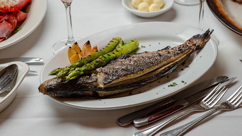 Seared whole fish filet with side of asparagus and lemon